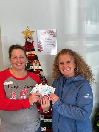 volunteers holding the gift cards that were donated